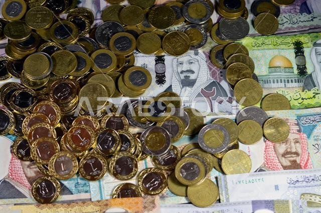 Coins of Saudi Arabian riyal, 2, 1, half and quarter coin on Saudi Arabia money banknotes of riyals bills, of different values, money and economic sta