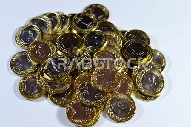 تتميز رزم العملات المعدنية من فئة ريال سعودي واحد بصورة الملك سلمان بن عبد العزيز، مع شعارات النبالة المتعددة داخل الزخارف النباتية، سعود