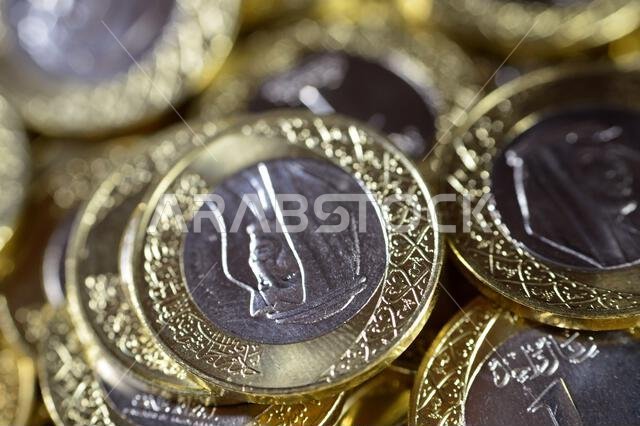Stacks of 1 One Saudi Arabian Riyal coin currency features King Salman Bin AbdulAziz, with Multiple Coat of Arms within the Floral Ornamentation, Saud