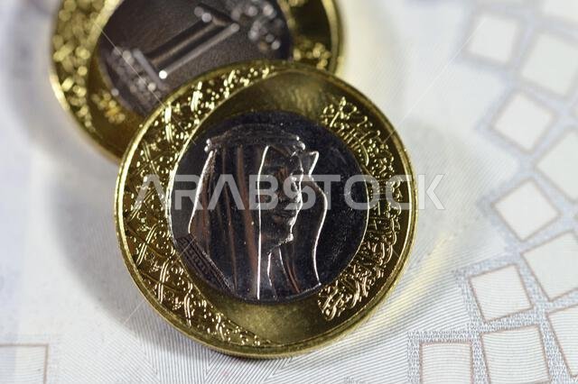 One SAR coin Saudi Arabian Riyal features King Salman Bin Abdul Aziz Al Saud on the obverse side, and Multiple Coat of Arms within the Floral Ornament One SAR coin Saudi Arabian Riyal features King Salman Bin Abdul Aziz Al Saud on the obverse side, and Multiple Coat of Arms within the Floral Ornament