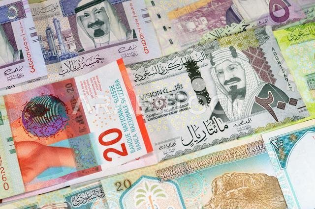 Switzerland cash money of Swiss Francs and Saudi Arabia money banknotes of riyals bills, of different values features various kings of Saudi Arabia, S