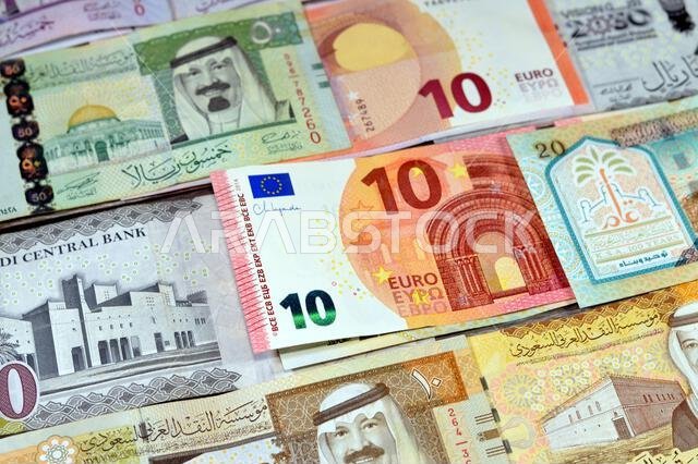 العملات الأوروبية: اليورو (EUR) والريال السعودي (SAR)، عملات ورقية من الريال السعودي بقيم مختلفة، تعكس الوضع الاقتصادي للعملة.