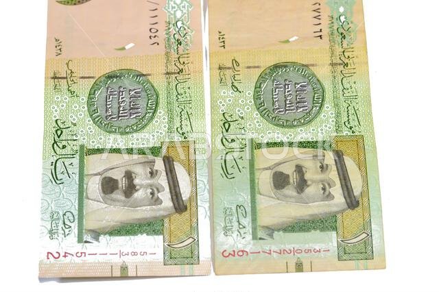 The Obverse side of 1 SAR one Saudi Arabian riyal banknote features king Abdullah Bin AbdulAziz, and the 1st Islamic coin, old ancient retro vintage S