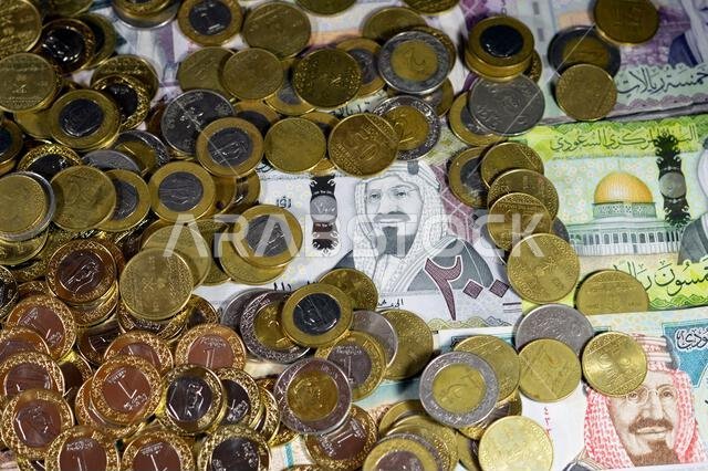 Coins of Saudi Arabian riyal, 2, 1, half and quarter coin on Saudi Arabia money banknotes of riyals bills, of different values, money and economic sta