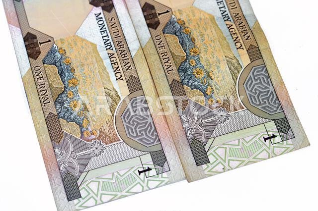Reverse side of an old Saudi Arabia banknote bill, one 1 Riyal SAR features a landscape scene and the Saudi Arabian national emblem of two swords belo