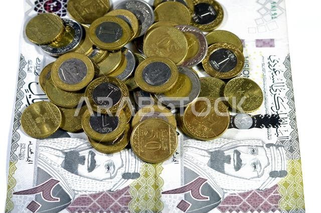 ورقة نقدية من فئة 200 ريال سعودي، تحمل صورة الملك عبد العزيز آل سعود ورؤية المملكة العربية السعودية لعام 2030، بالإضافة إلى عملات معدنية سعودية من فئة ريالين. ورقة نقدية من فئة 200 ريال سعودي، تحمل صورة الملك عبد العزيز آل سعود ورؤية المملكة العربية السعودية لعام 2030، بالإضافة إلى عملات معدنية سعودية من فئة ريالين.