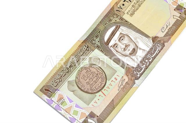 يُظهر الوجه الأمامي لورقة نقدية قديمة من المملكة العربية السعودية، فئة ريال واحد، صورة فهد بن عبد العزيز آل سعود، خادم الحرمين الشريفين، و...