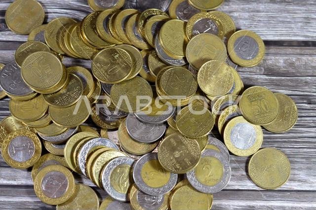 عملات معدنية متنوعة من المملكة العربية السعودية بقيم وأزمنة مختلفة، وعملة الريال السعودي القديمة والجديدة من فئات ريالين، وريال واحد، ونصف ريال، وربع ريال. عملات معدنية متنوعة من المملكة العربية السعودية بقيم وأزمنة مختلفة، وعملة الريال السعودي القديمة والجديدة من فئات ريالين، وريال واحد، ونصف ريال، وربع ريال.