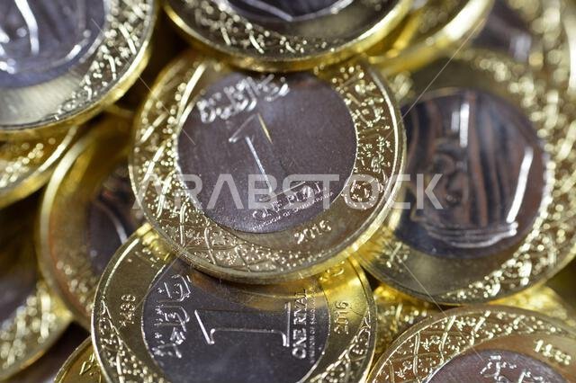 Stacks of 1 One Saudi Arabian Riyal coin currency features King Salman Bin AbdulAziz, with Multiple Coat of Arms within the Floral Ornamentation, Saud