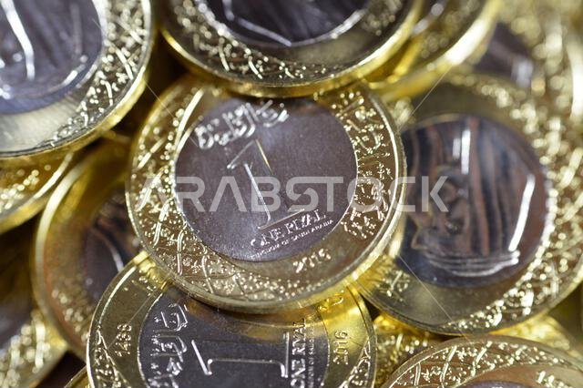 Stacks of 1 One Saudi Arabian Riyal coin currency features King Salman Bin AbdulAziz, with Multiple Coat of Arms within the Floral Ornamentation, Saud