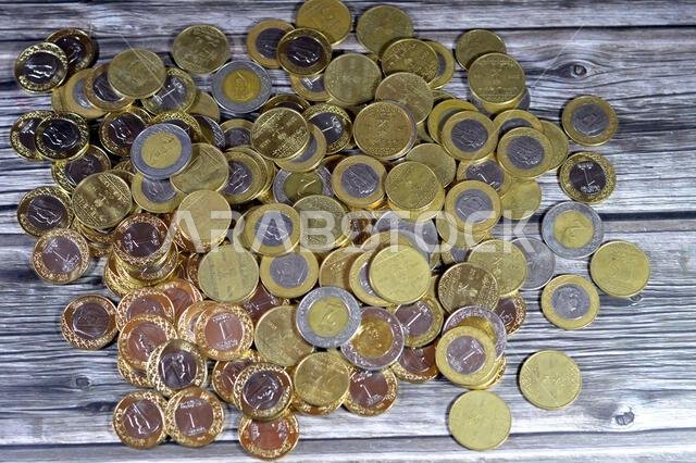 عملات معدنية متنوعة من المملكة العربية السعودية بقيم وأزمنة مختلفة، وعملة الريال السعودي القديمة والجديدة من فئات ريالين، وريال واحد، ونصف ريال، وربع ريال. عملات معدنية متنوعة من المملكة العربية السعودية بقيم وأزمنة مختلفة، وعملة الريال السعودي القديمة والجديدة من فئات ريالين، وريال واحد، ونصف ريال، وربع ريال.