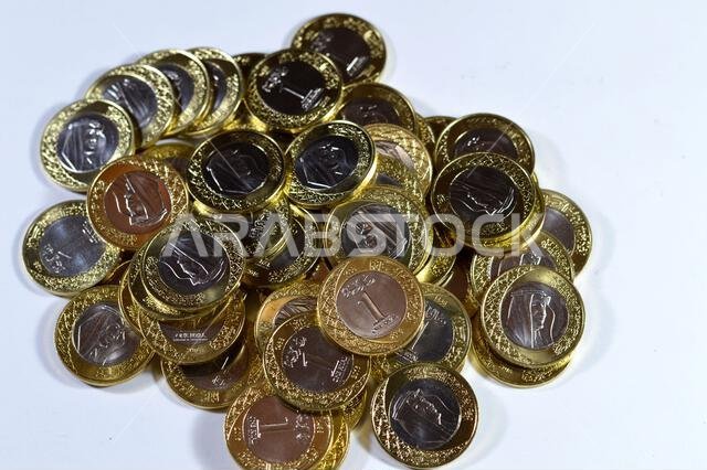 تتميز رزم العملات المعدنية من فئة ريال سعودي واحد بصورة الملك سلمان بن عبد العزيز، مع شعارات النبالة المتعددة داخل الزخارف النباتية، سعود