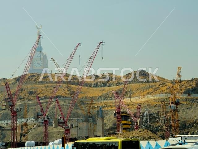 مكة المكرمة، المملكة العربية السعودية، 8 يونيو 2024: مبنى برج الساعة، رافعات موقع البناء، وجبال مكة المكرمة، عاصمة محافظة مكة المكرمة.
