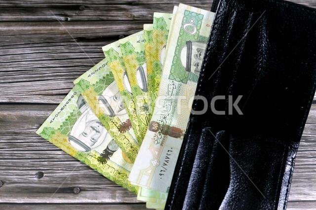 أوراق نقدية من الريال السعودي، رزمة من الأوراق النقدية بالريال السعودي في محفظة جلدية سوداء، شراء، بيع، بيع، المال والوضع الاقتصادي.