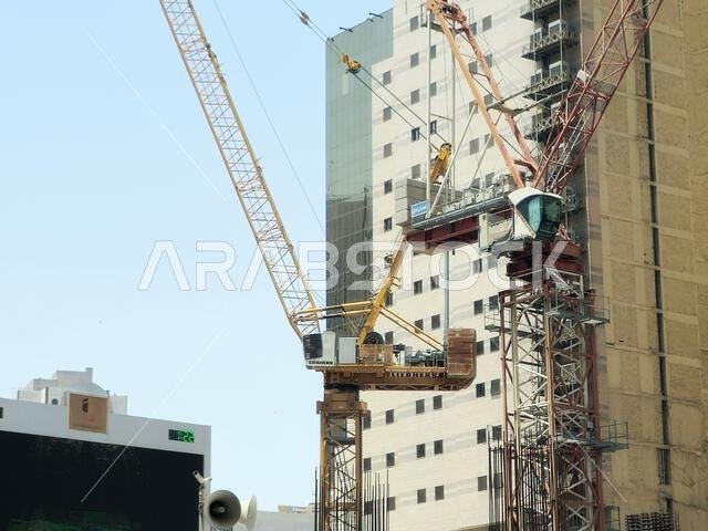 Mecca, Saudi Arabia, June 4 2024: A new building under construction, with crane towers in Makkah city near Al Haram and the Kaaba, new developmental p