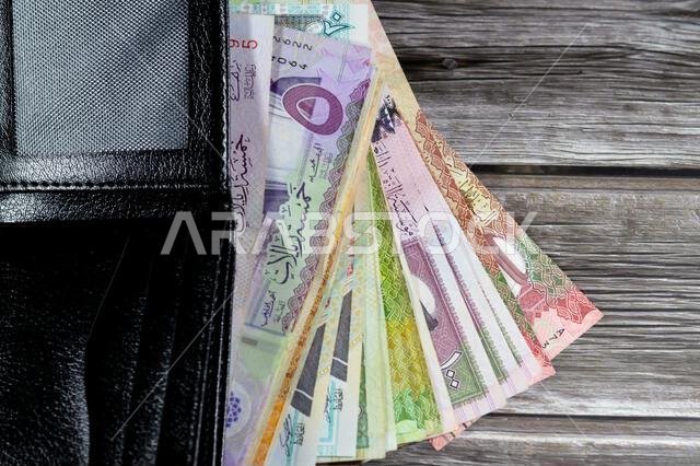 أوراق نقدية من الريال السعودي، رزمة من الأوراق النقدية بالريال السعودي في محفظة جلدية سوداء، شراء، بيع، بيع، المال والوضع الاقتصادي. أوراق نقدية من الريال السعودي، رزمة من الأوراق النقدية بالريال السعودي في محفظة جلدية سوداء، شراء، بيع، بيع، المال والوضع الاقتصادي.