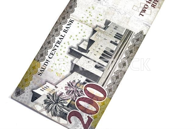 يُظهر الوجه الخلفي للورقة النقدية من فئة 200 ريال سعودي قصر الحكم في مدينة الرياض، مع اسم البنك أعلى الصورة ورمز المنطقة.
