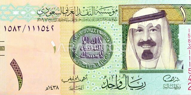 Large fragment of obverse side of 1 SAR one Saudi Arabian riyal banknote features king Abdullah Bin AbdulAziz, and the 1st Islamic coin, old ancient r
