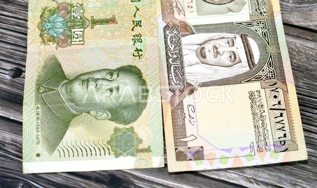 Saudi Arabian riyal bill and 1 one Chinese Yuan cash money bill banknote issued by People's Bank of China, Saudi Arabia and Chinese currency exchange