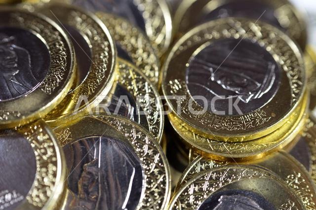 تتميز رزم العملات المعدنية من فئة ريال سعودي واحد بصورة الملك سلمان بن عبد العزيز، مع شعارات النبالة المتعددة داخل الزخارف النباتية، سعود