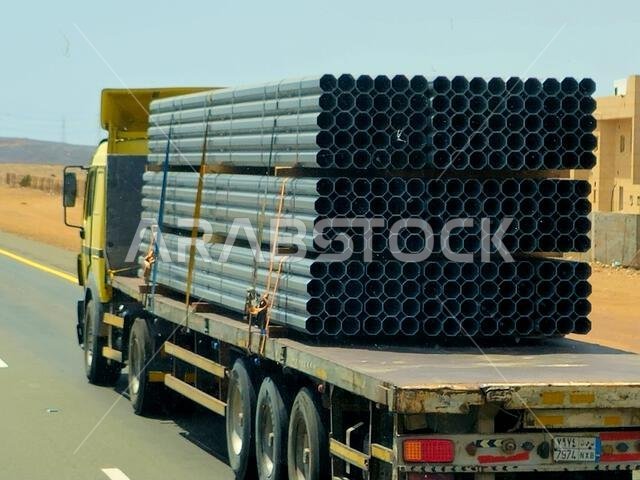 Makkah Madinah road, Saudi Arabia, June 25 2024: A big flatbed truck loaded with a shipment being transferred on a highway with a large lorry, shipmen Makkah Madinah road, Saudi Arabia, June 25 2024: A big flatbed truck loaded with a shipment being transferred on a highway with a large lorry, shipmen