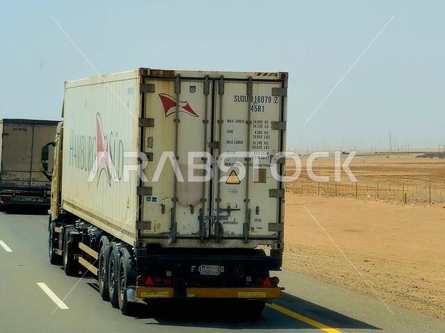 Makkah Madinah road, Saudi Arabia, June 25 2024: flatbed truck big vehicle with a steel shipment container on it on a highway in Saudi, shipment and d