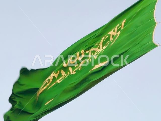 العلم الوطني للمملكة العربية السعودية، خلفية خضراء عليها كتابة عربية وسيف أبيض عليه كتابة للعقيدة الإسلامية، أو