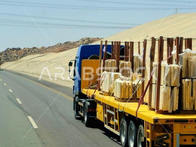Makkah Madinah road, Saudi Arabia, June 25 2024: A big flatbed truck loaded with a shipment being transferred on a highway with a large lorry, shipmen Makkah Madinah road, Saudi Arabia, June 25 2024: A big flatbed truck loaded with a shipment being transferred on a highway with a large lorry, shipmen