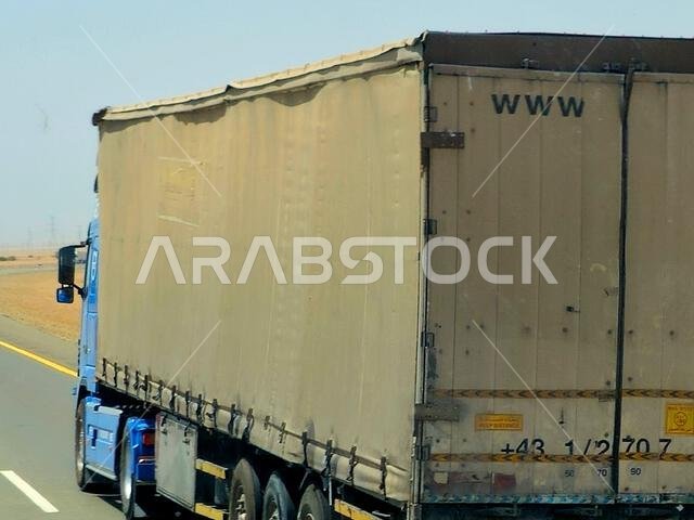 Makkah Madinah road, Saudi Arabia, June 25 2024: flatbed truck big vehicle with a steel shipment container on it on a highway in Saudi, shipment and d Makkah Madinah road, Saudi Arabia, June 25 2024: flatbed truck big vehicle with a steel shipment container on it on a highway in Saudi, shipment and d
