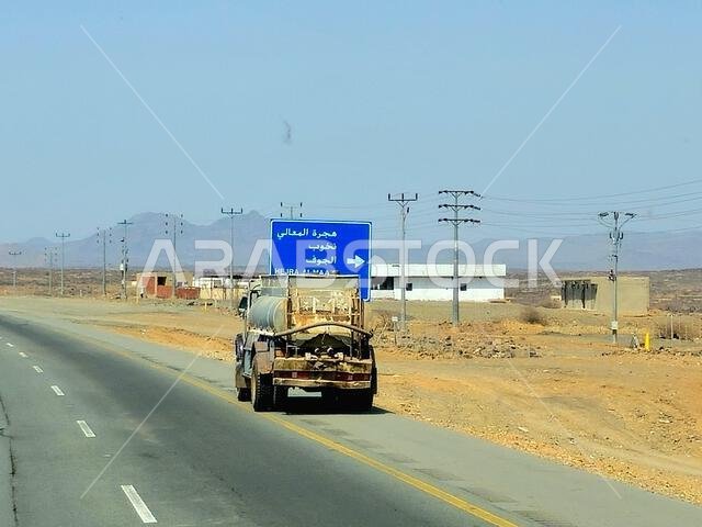 Makkah Madinah road, Saudi Arabia, June 25 2024: Tanker truck with a container tank with liquid products, a lorry on the highway with a container on i