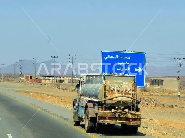 Makkah Madinah road, Saudi Arabia, June 25 2024: Tanker truck with a container tank with liquid products, a lorry on the highway with a container on i