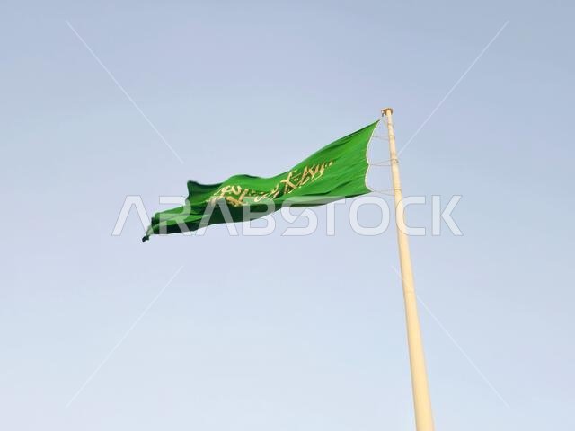 العلم الوطني للمملكة العربية السعودية، خلفية خضراء عليها كتابة عربية وسيف أبيض عليه كتابة للعقيدة الإسلامية، أو