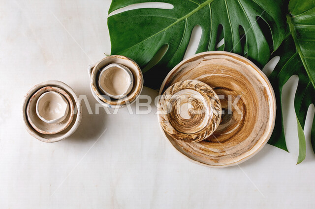 صورة مقربة لطبق سيراميك فارغ فوق اوراق الاشجار، اكواب سيراميك، تصميمات ابداعية، خلفية بيضاء