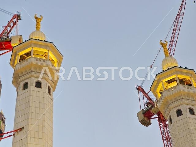 مآذن المسجد الحرام المحيطة بالكعبة المشرفة في الحج والعمرة، مع أبراج رافعات تحيط بها لأغراض الصيانة والإنشاء.
