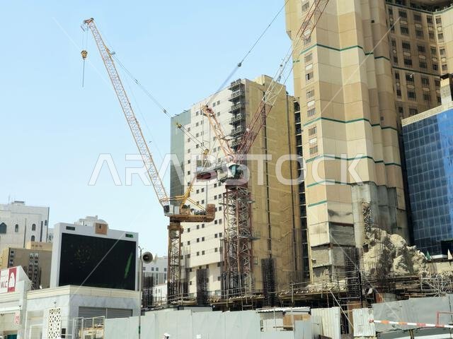 Mecca, Saudi Arabia, June 4 2024: A new building under construction, with crane towers in Makkah city near Al Haram and the Kaaba, new developmental p