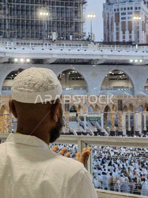 رجل عربي خليجي سعودي يرفع يديه للدعاء والمناجاة داخل الحرم المكي في مكة المكرمة في المملكة العربية السعودية ، أداء مناسك الحج والعمرة ، الطواف حول الكعبة ، العبادة والتقرب الى الله ، معالم دينية اسلامية في السعودية