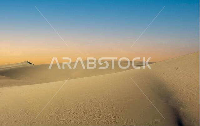 the sun sets between the desert dunes