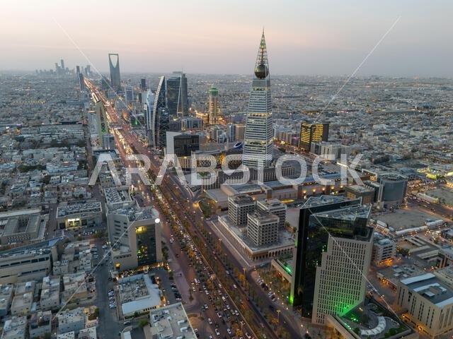 Al Faisaliah Tower pyramid-shaped commercial skyscraper. Riyadh. Drone shot flying. Sunset. Evening.