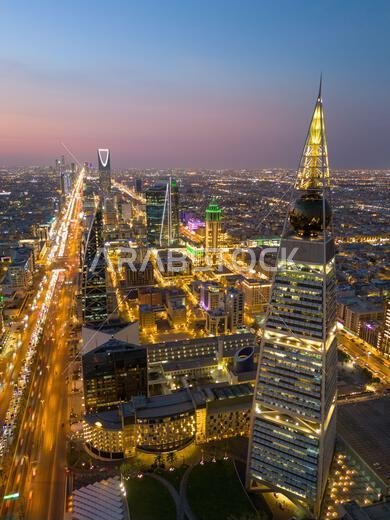 Al Faisaliah Tower pyramid-shaped commercial skyscraper. Riyadh. Drone shot flying. Sunset. Evening.