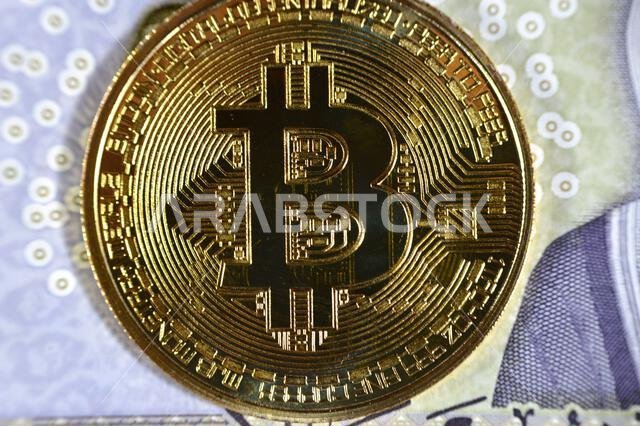 Saudi Arabia riyals banknote with Bitcoin physical golden coin, BTC the 1st decentralized cryptocurrency, nodes in P2P bitcoin network verify transact