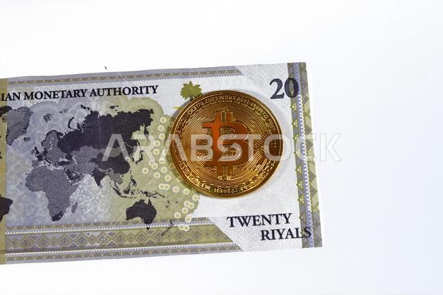 Saudi Arabia riyals banknote with Bitcoin physical golden coin, BTC the 1st decentralized cryptocurrency, nodes in P2P bitcoin network verify transact