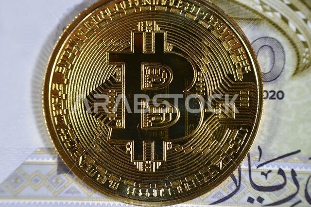 Saudi Arabia riyals banknote with Bitcoin physical golden coin, BTC the 1st decentralized cryptocurrency, nodes in P2P bitcoin network verify transact