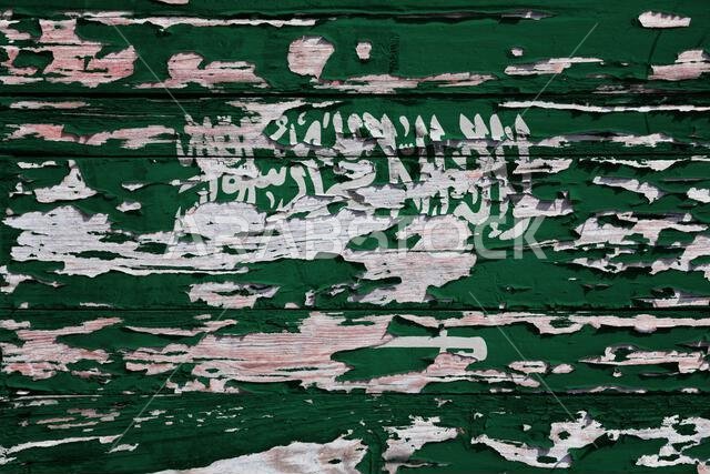 علم المملكة العربية السعودية مرسوم على لوح خشبي ذي مظهر عتيق.