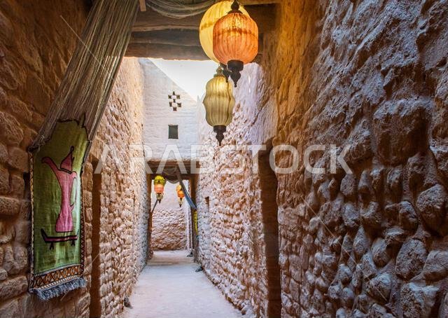 العلا، المملكة العربية السعودية، 3 أبريل 2024. منظر داخلي لمدينة العلا القديمة مع زقاق ضيق ومنازل تقليدية وفوانيس.