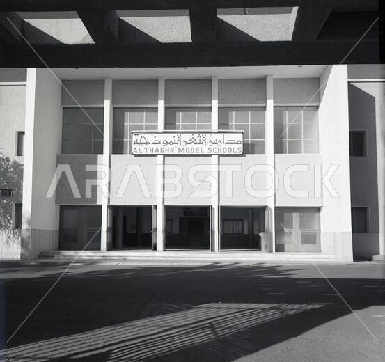 ستينيات القرن العشرين، صورة تاريخية، مدخل مدارس الثغر النموذجية، جدة، المملكة العربية السعودية. أسسها ملك المملكة العربية السعودية (فيصل بن عبد العزيز آل سعود) عام ١٩٦٤ في مبنى حديث من طابقين بجناحين، أحدهما لطلاب المرحلة المتوسطة والآخر لطلاب المرحلة الثانوية. كانت مساكن الطلاب والسكن الداخلي في الطابق الثاني. كانت هذه المؤسسة التعليمية المرموقة تُدرَّس فيها اللغة الإنجليزية، وكان الطلاب يرتدون زيًا مدرسيًا على الطراز الغربي، على عكس المدارس السعودية الأخرى.