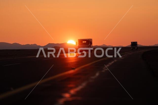 غروب الشمس الذهبي فوق الطريق الصحراوي السريع، رحلة برية خلابة ومغامرة. المملكة العربية السعودية. 