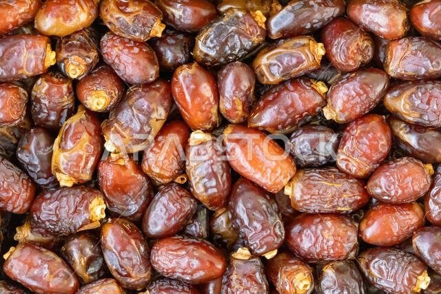 ثمار نخيل مجففة كخلفية. التمر فاكهة شائعة تُستهلك خلال شهر رمضان المبارك.