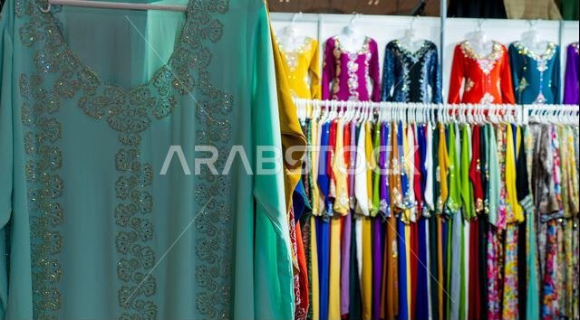 Doha, Qatar, October 18, 2024: Traditional Arabic abayas and clothing are displayed for sale at a cloth store in Souq Waqif, featuring intricate desig
