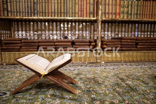يُفتح كتاب القرآن الكريم على سجادة خضراء في المسجد النبوي في مدينة المدينة المنورة بالمملكة العربية السعودية.