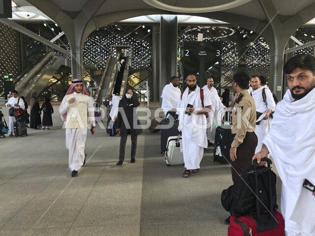 صورة لحجاج بيت الله الحرام بملابس الإحرام البيضاء يتنقلون عبر قطار الحرمين السريع في مكة المكرمة ، محطة الرصيفة في مكة المكرمة ، خدمات نقل الحجاج للمسجد الحرام ، خدمات نقل آمنة و مريحة في موسم الحج